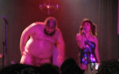 A large man in a loincloth and the singer from Gravy Train.